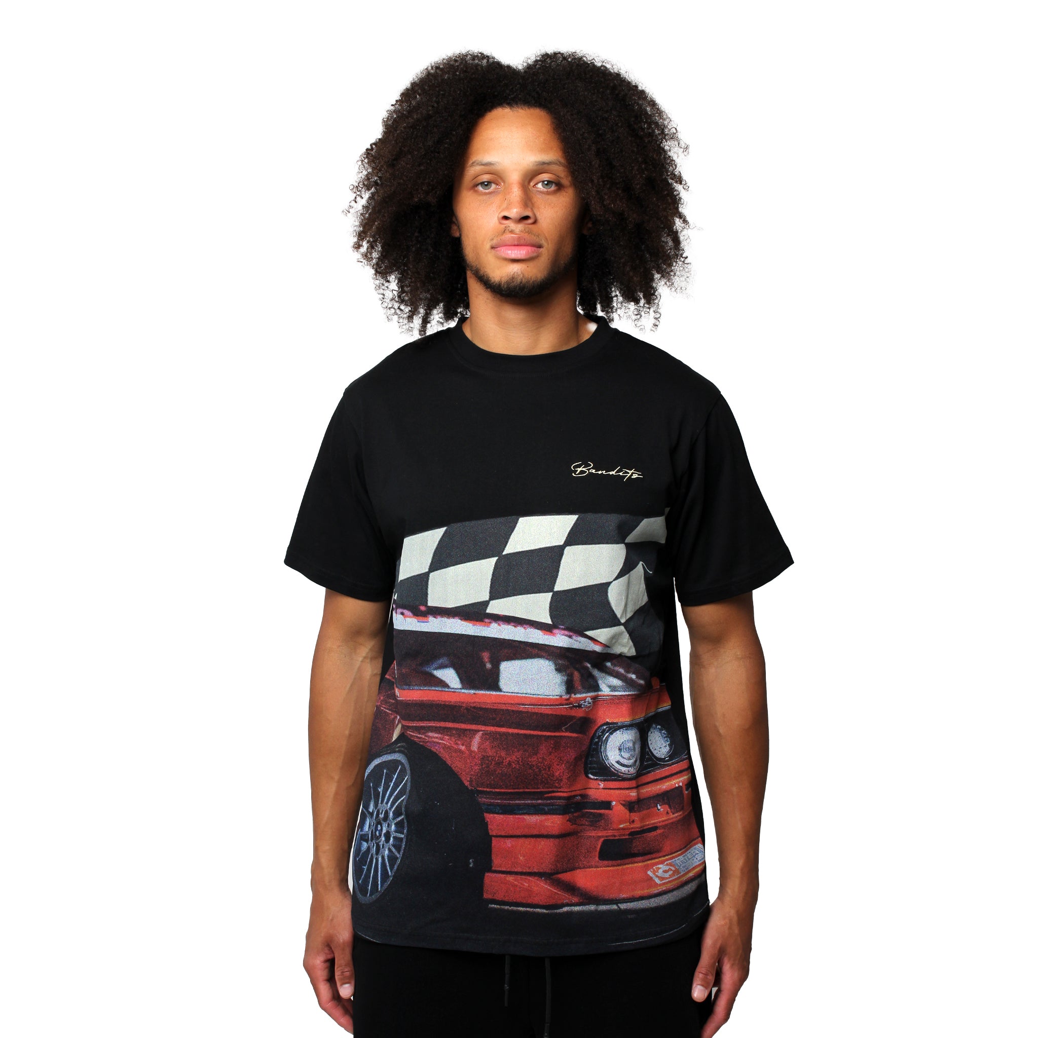 A person with curly hair wears the BBS S/S TEE BLACK, a DTG printed black t-shirt showcasing a red sports car and a black-and-white checkered flag graphic on the front, standing against a plain white background.