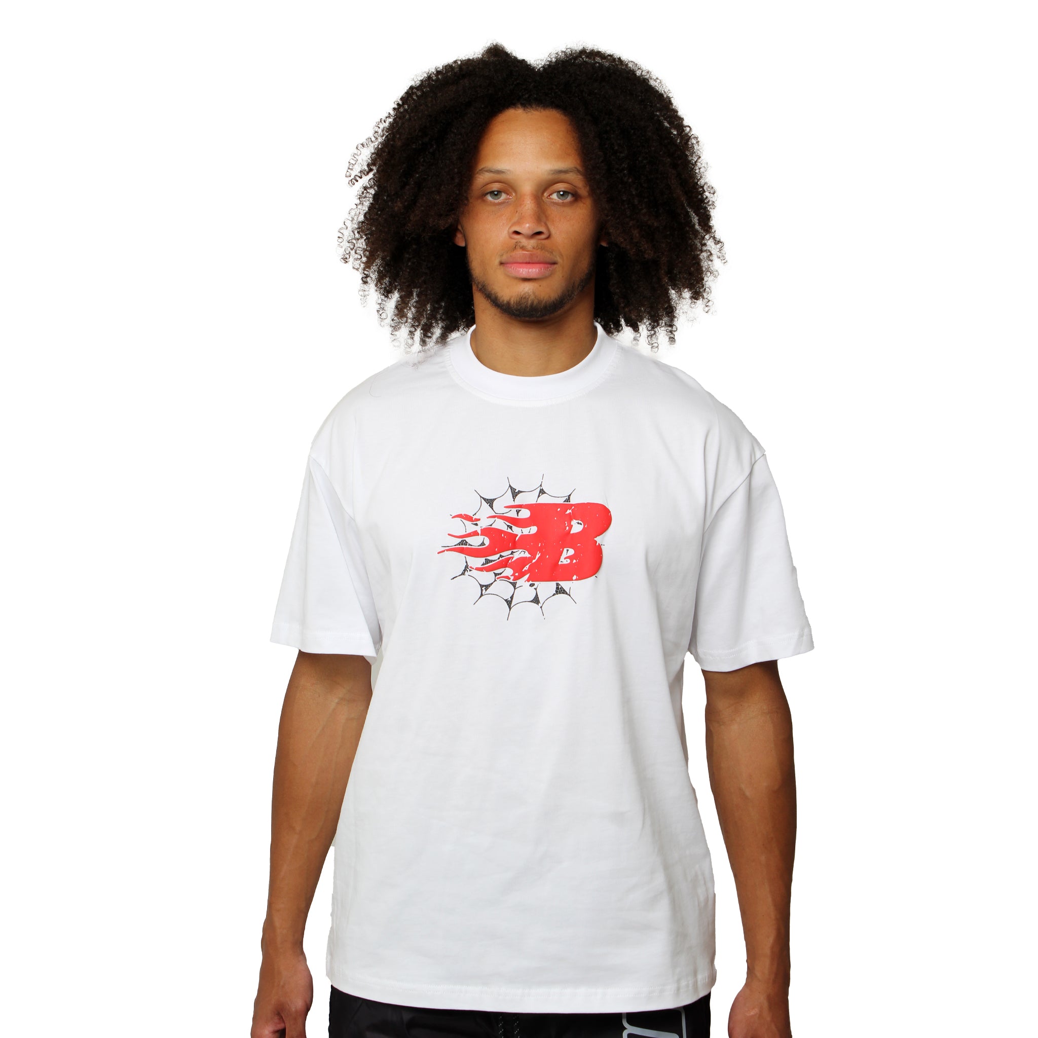 A person with curly hair wears the BEAT THE ODDS S/S TEE WHITE, featuring a bold red B with black flames and star accents, exuding galactic style as they stand facing forward against a plain white background.