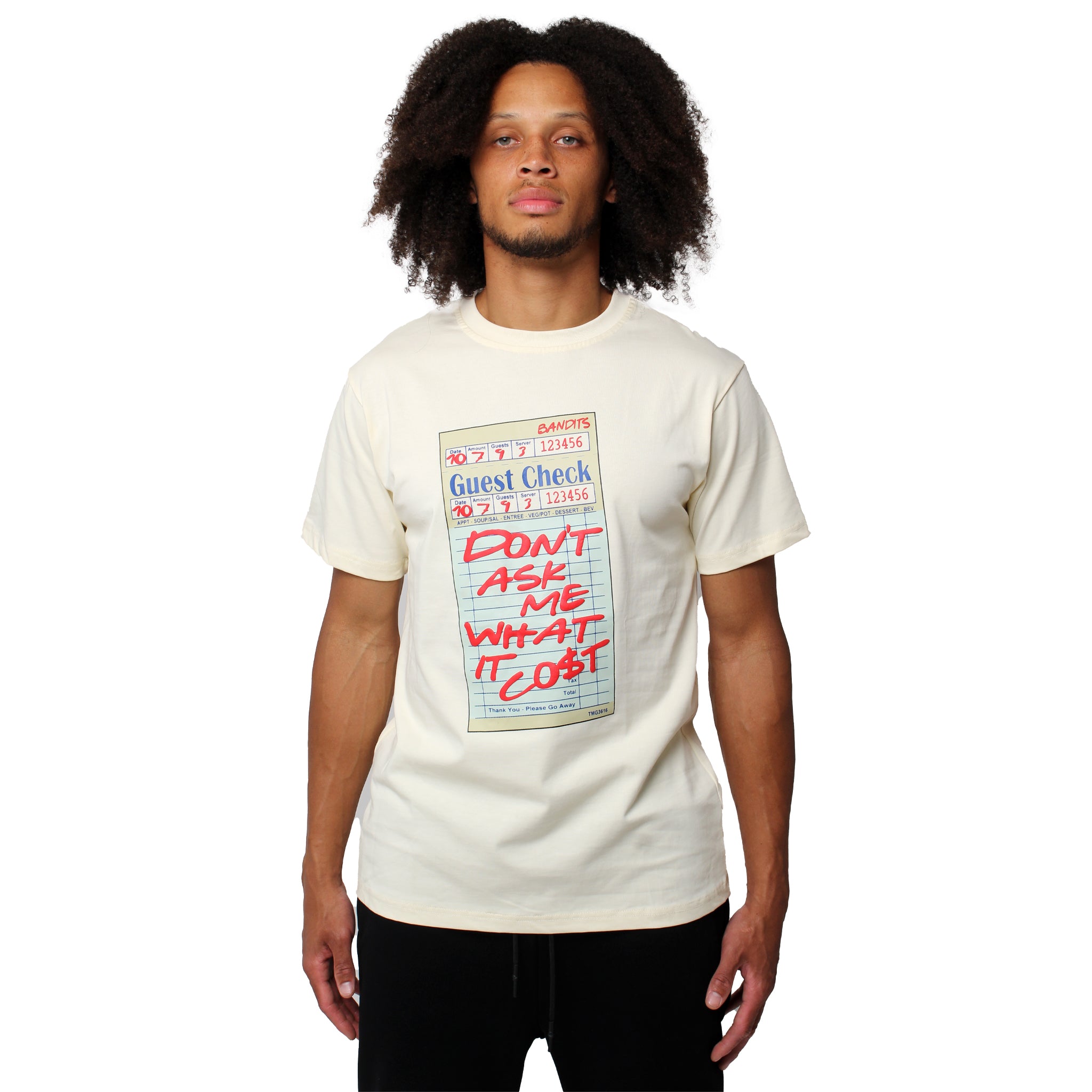 A person with curly hair wears the GUEST CHECK S/S TEE CREME, a vintage-style shirt featuring a bold guest check graphic and "DONT ASK ME WHAT IT COST" in red on a light-colored tee.