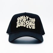 The ONLY THE STRONG SURVIVE TRUCKER is a black hat featuring bold, wavy white 3D embroidered text on the front and an adjustable snapback for a perfect fit. Shown against a plain white background.