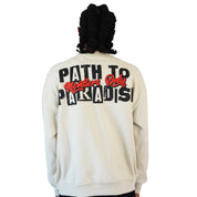 A person with dark, shoulder-length hair wears the PATH TO PARADISE CREWNECK SWEATSHIRT in tan. The oversized crewneck features bold “PATH TO PARADISE” text on the back, with “Members Only” in red script—a standout streetwear piece.