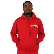 A man stands facing forward with both hands in the pocket of a bright red BIKER CLUB PULLOVER HOODY RED, featuring "BANDITS" in white on the left chest, against a plain white background.