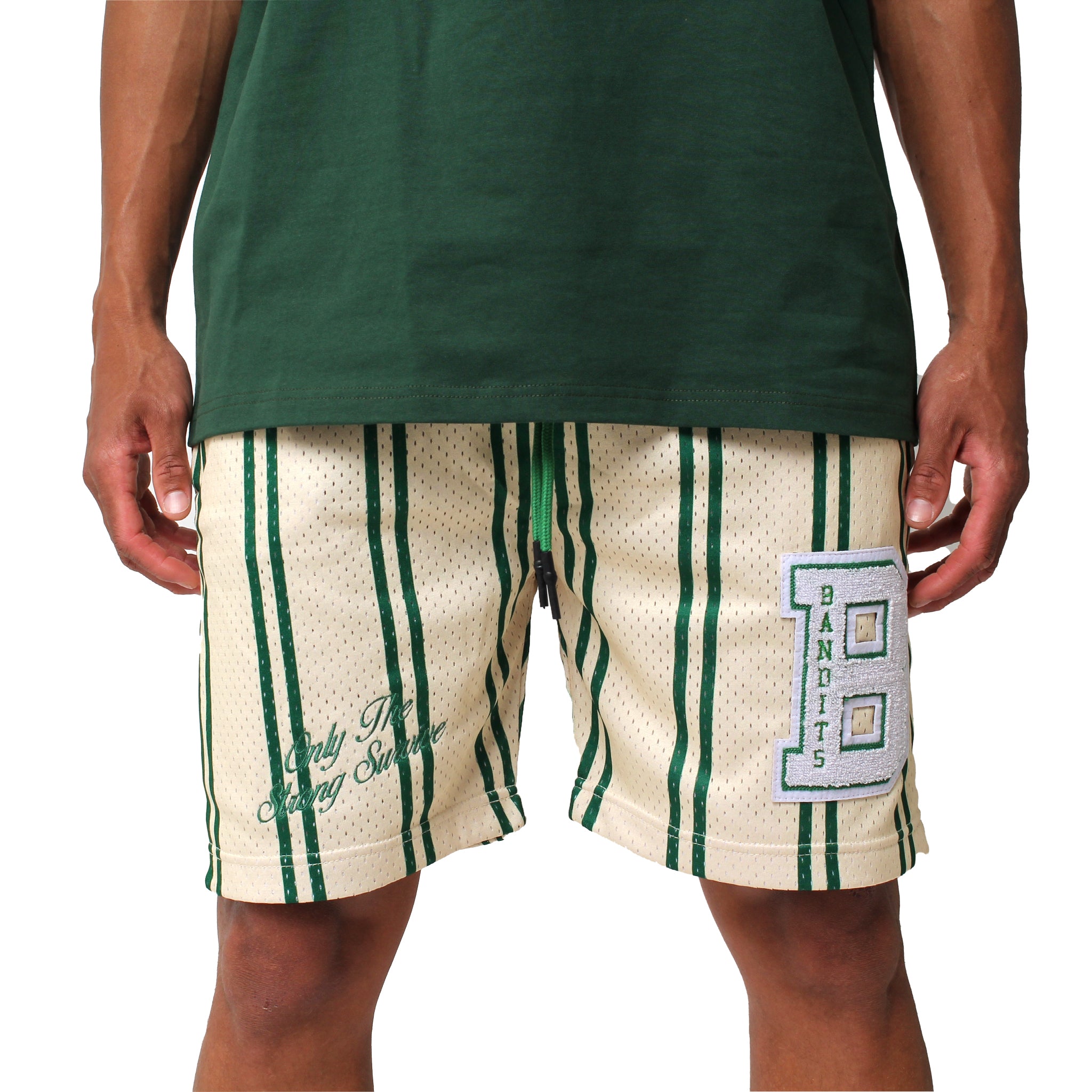 A person wears ONLY THE STRONG SURVIVE MESH SHORTS CREME featuring double-layered mesh, green stripes, a large chenille varsity B patch, and “Bandits,” paired with a green shirt. Only the lower torso and legs are shown.